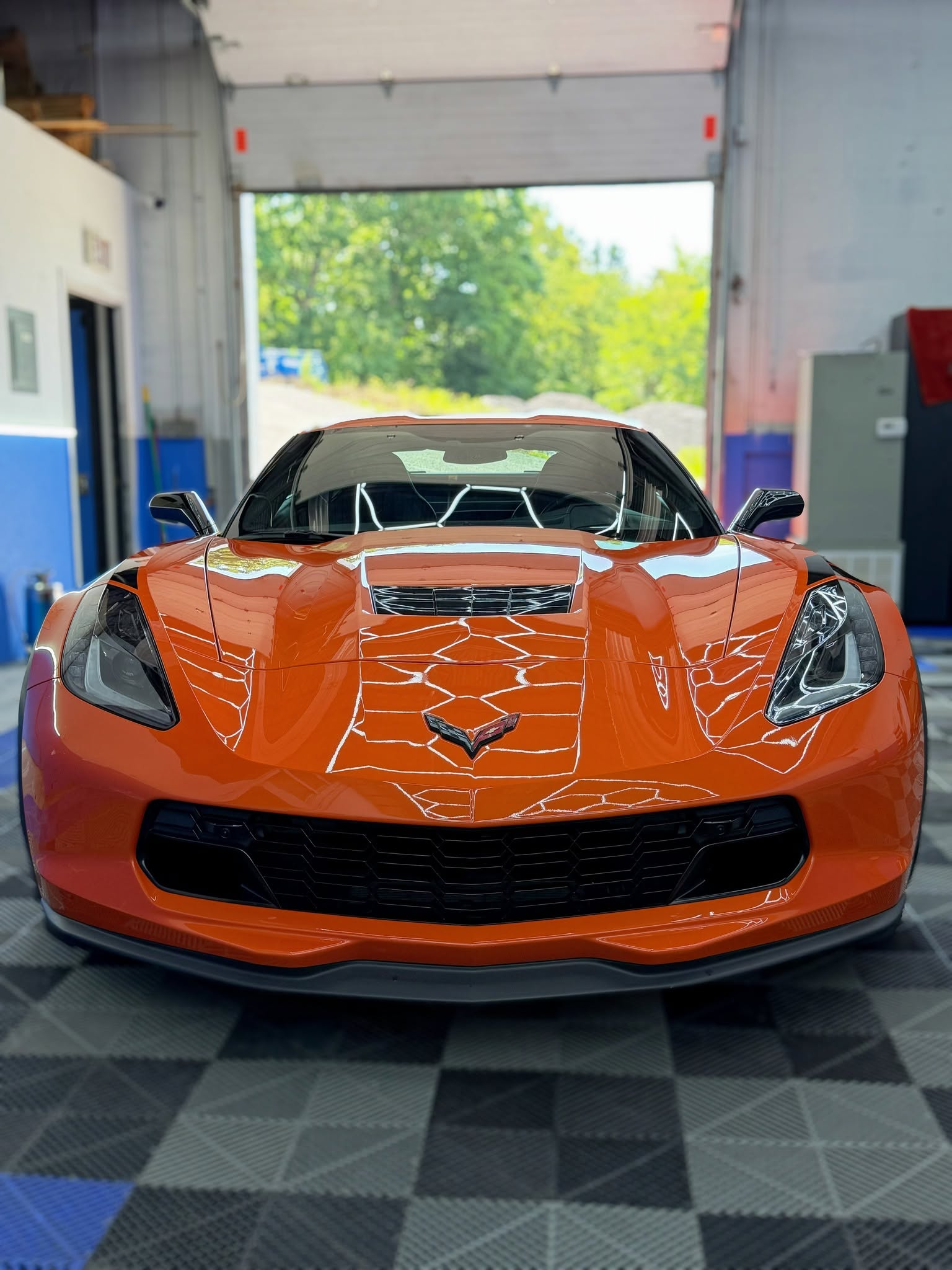 Orange Corvette showcasing crisp surface clarity under detailing lights